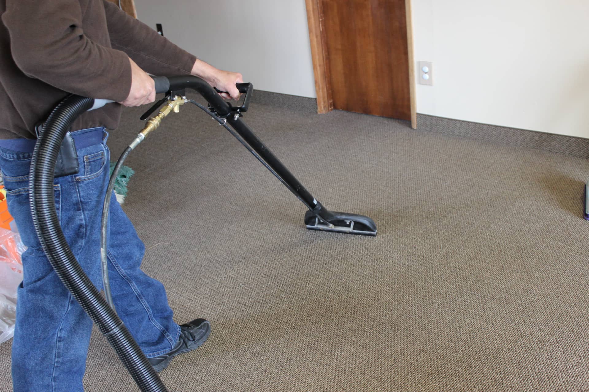 man carpet cleaning in empty office